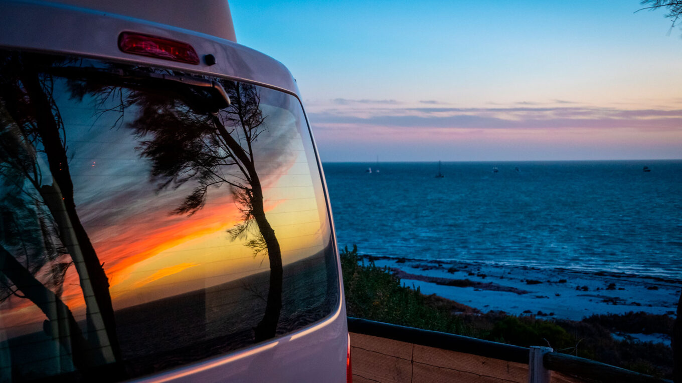 Solnedgang spejlet i bagruden på campervan i Australien - øjeblikke du kun får på en camperroadtrip.