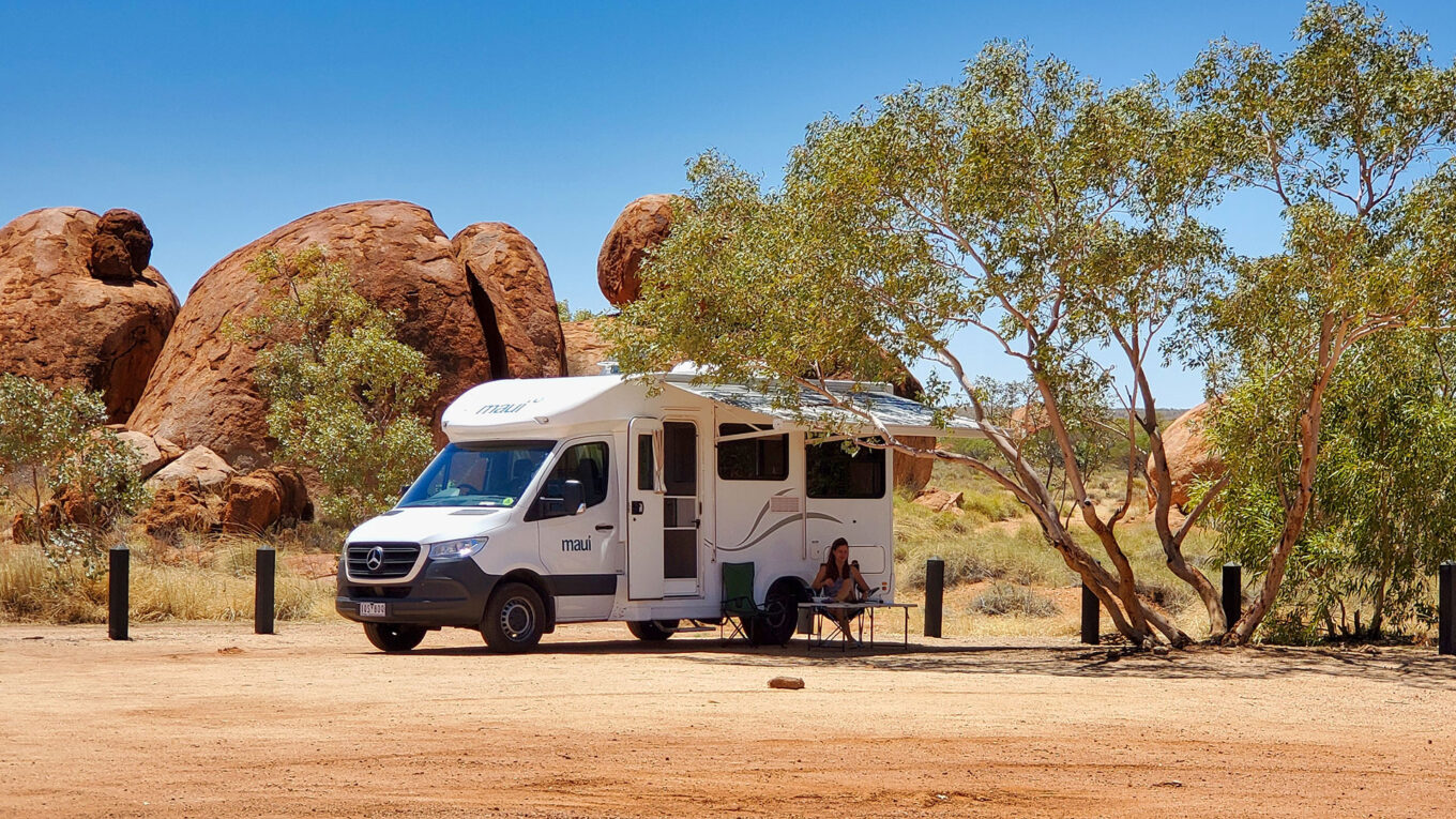 Autocamper med markise slået ud i Australiens outback - camping under åben himmel.