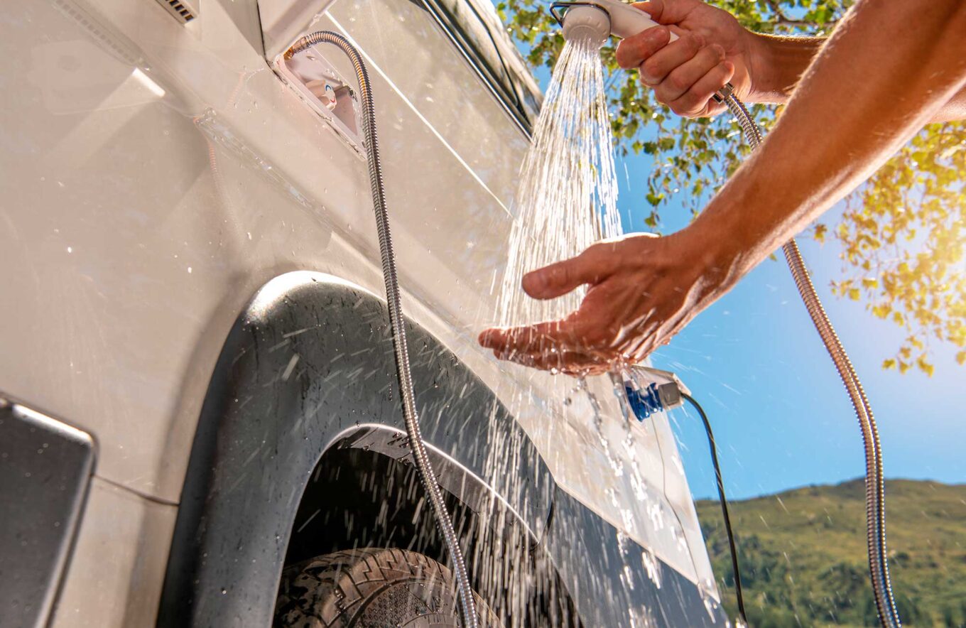 Person vasker en campervan udendørs før afrejse