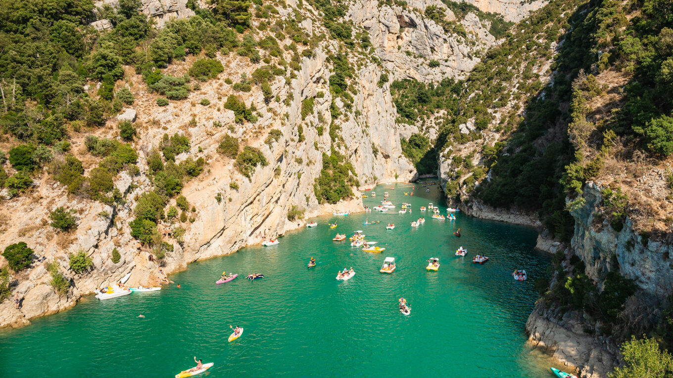 Farverige både i den turkise flod mellem klipperne ved Gorges du Verdon i Provence