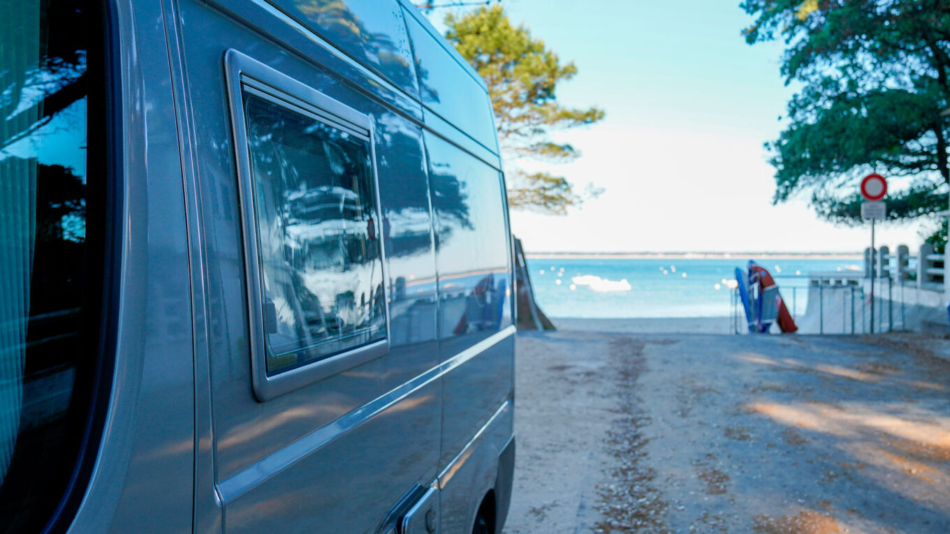 Campervan parkeret tæt på stranden med udsigt over Middelhavet på en autocamperferie i Frankrig