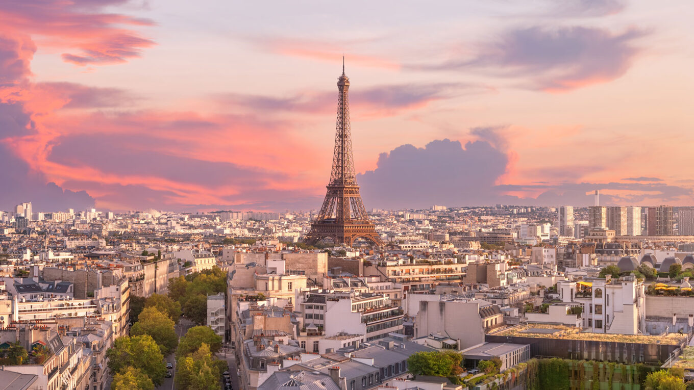 Solnedgang over Paris med Eiffeltårnet og byens tage i forgrunden