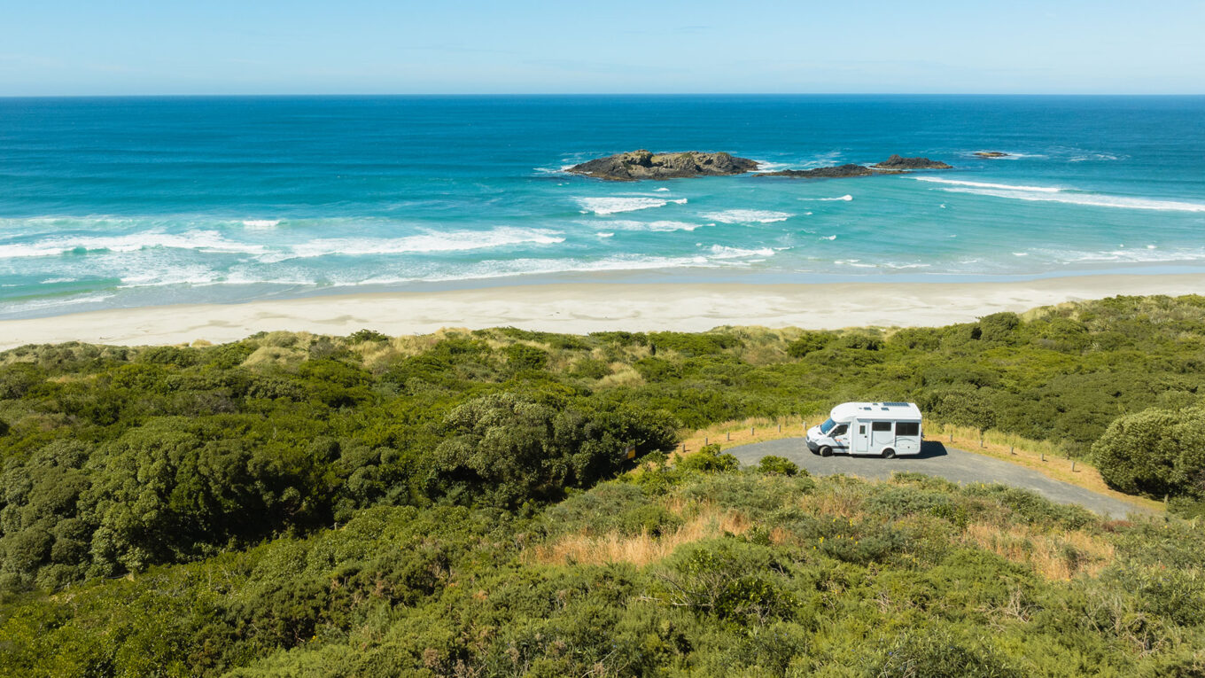 Autocamper parkeret nær kysten ved Smails Beach på Sydøen – naturoplevelser lige uden for døren.