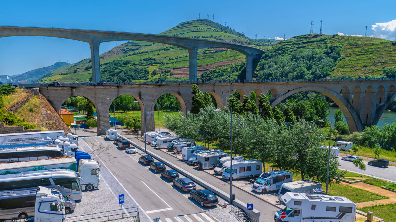 Stellplads med autocampere og udsigt til gamle og nye broer ved Peso da Régua i Portugal