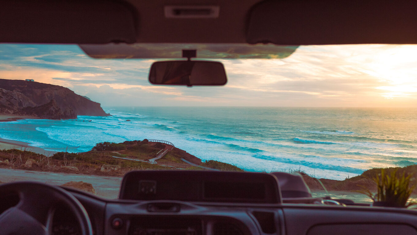 Udsigt til Atlanterhavet og solnedgang fra forruden i en autocamper i Portugal
