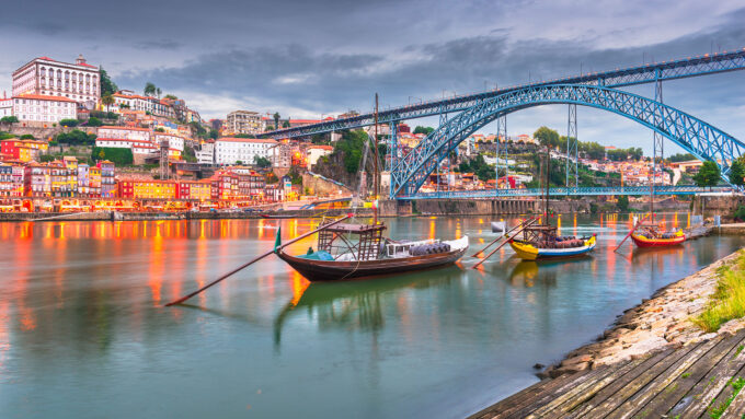 Farverige huse og traditionelle både ved Dourofloden i Porto, perfekt stop på en autocamperrejse i Portugal