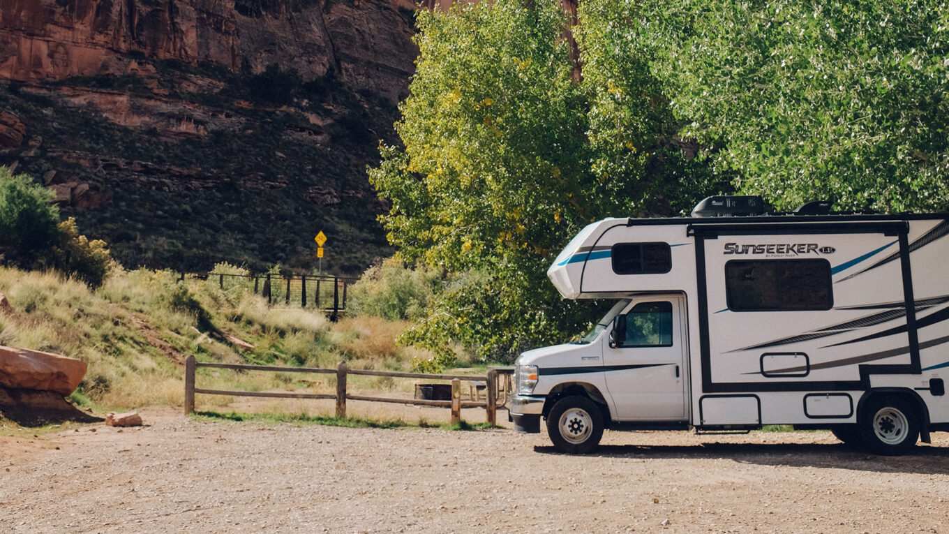 Klassisk amerikansk autocamper parkeret tæt på Arches National Park omgivet af klipper – fantastisk base for oplevelser i naturen.