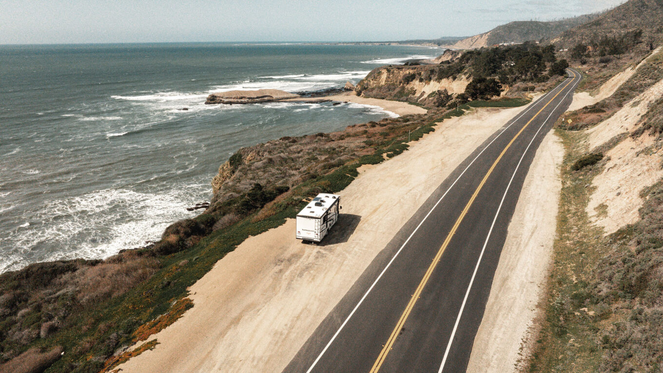 Autocamper parkeret ved den ikoniske Pacific Coast Highway med udsigt over Stillehavet – klassisk roadtrip i Californien.